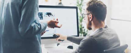 A man pointing to computer screen