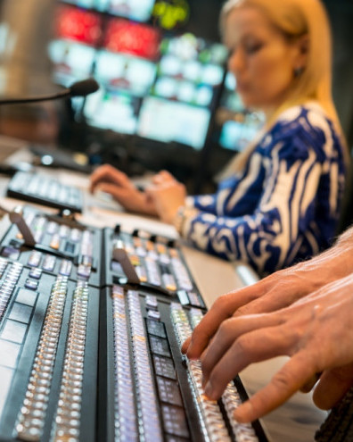 Hands working on keyboard in TV control centre